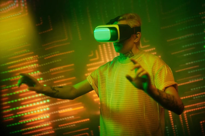 A man wearing a vr headset in front of green lights.